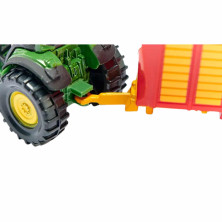 Tráiler de silo SIKU con compuerta trasera funcional acoplado a tractor verde, ideal para juego de granja.